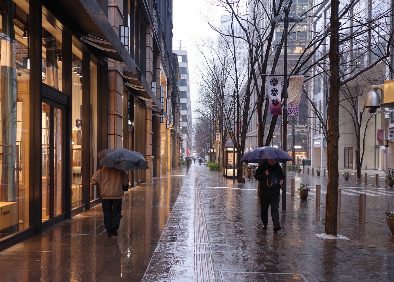 雨中的城市人行道與撐傘行人